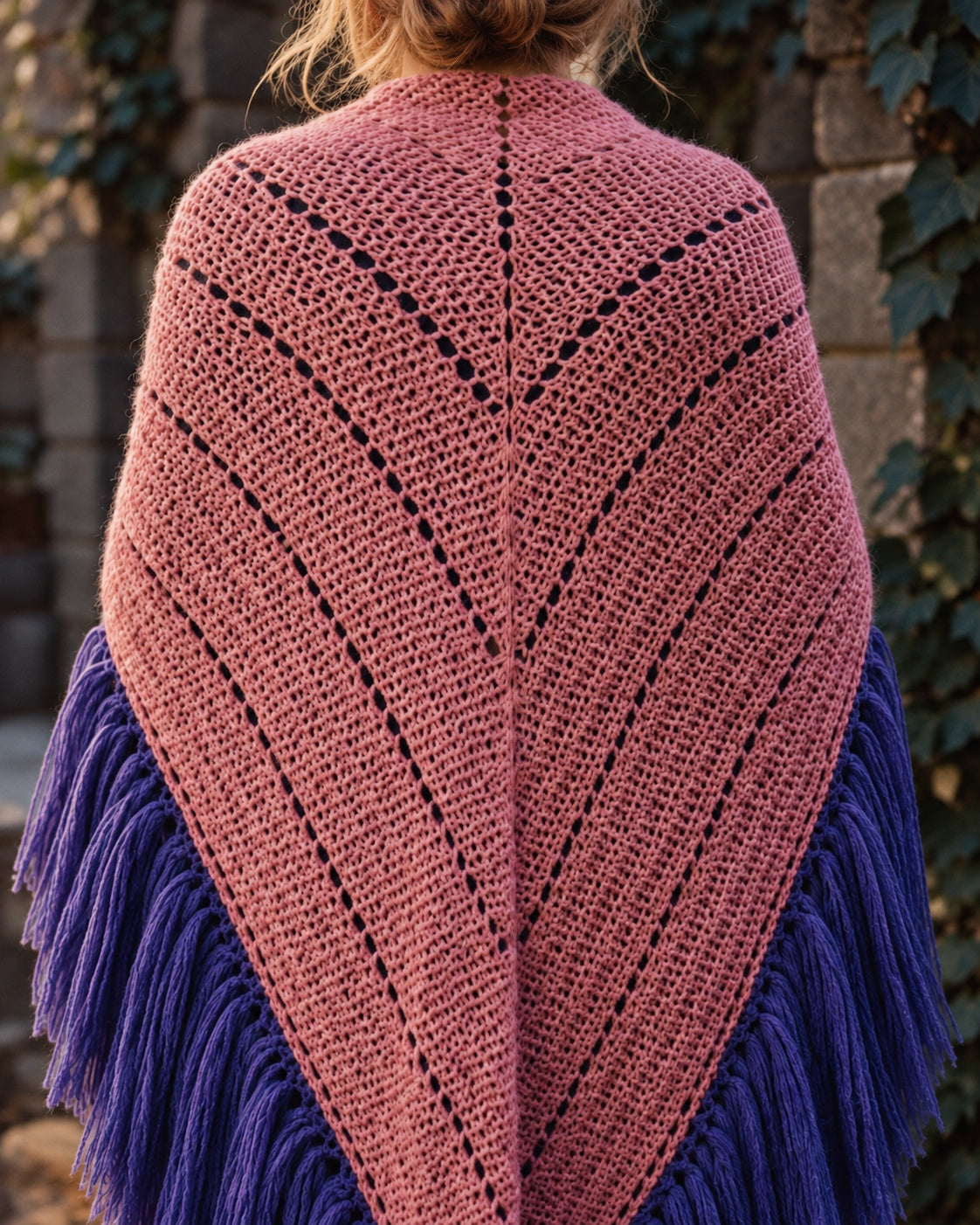 Donna di spalle con lo scialle Odette rosa antico, trafori a linee diagonali e frange viola